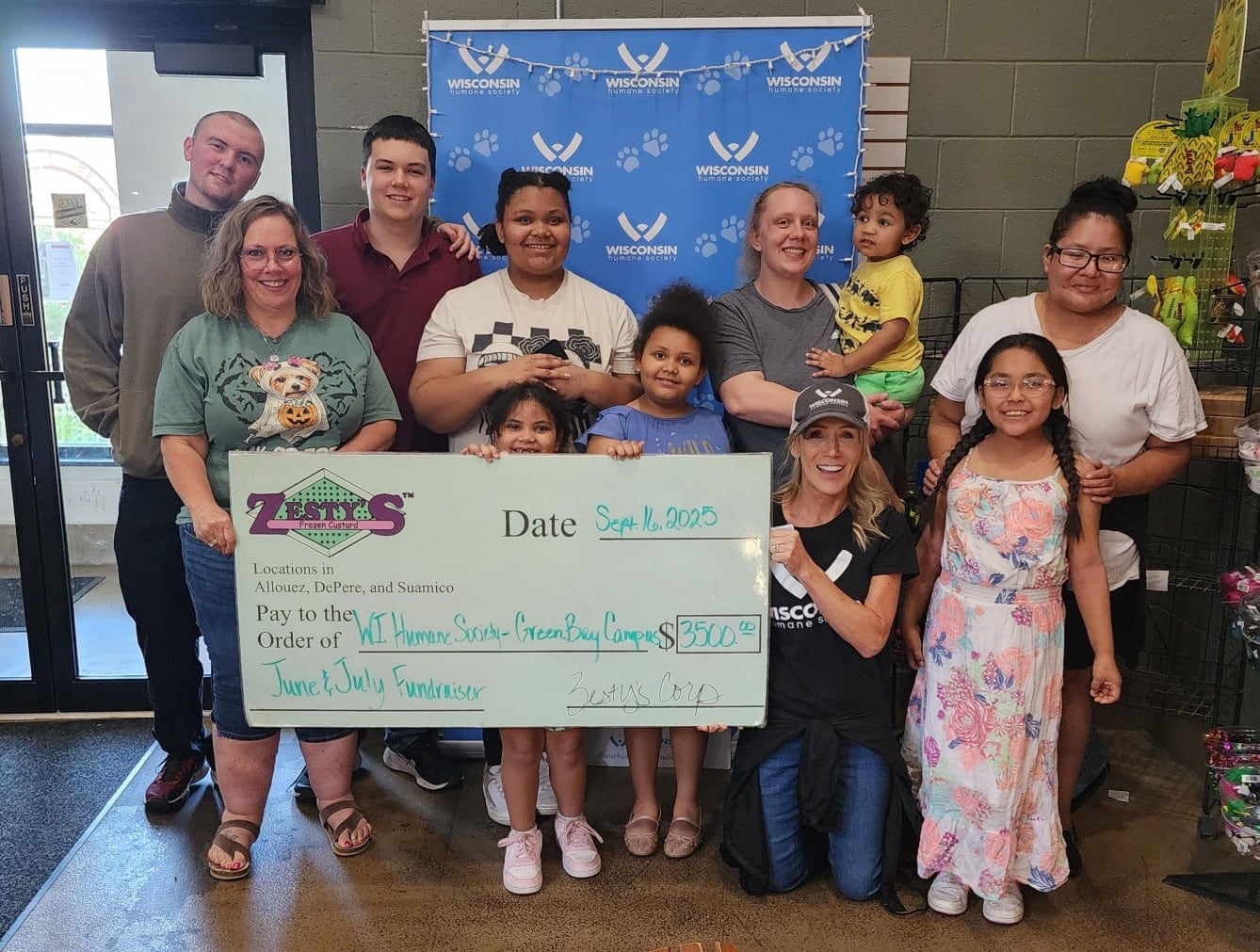 Group of people smile with giant donation check for WHS