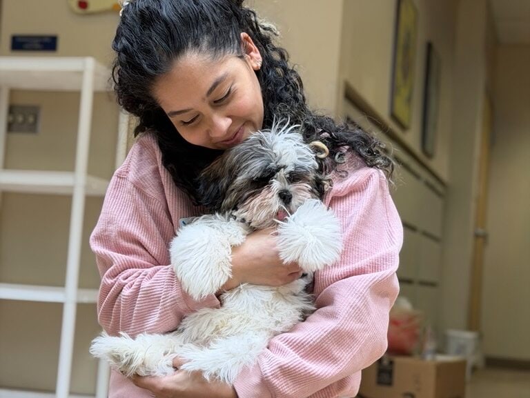 woman cradles fluffy puppy