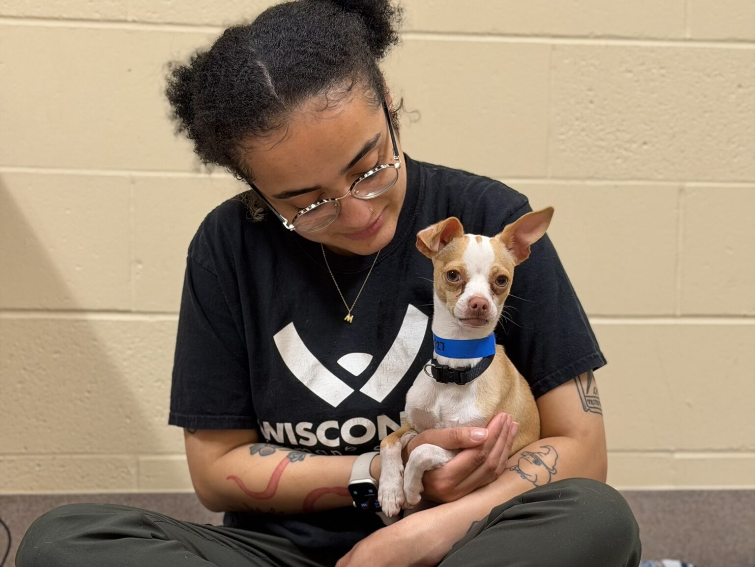 person sitting on floor with dog in lap